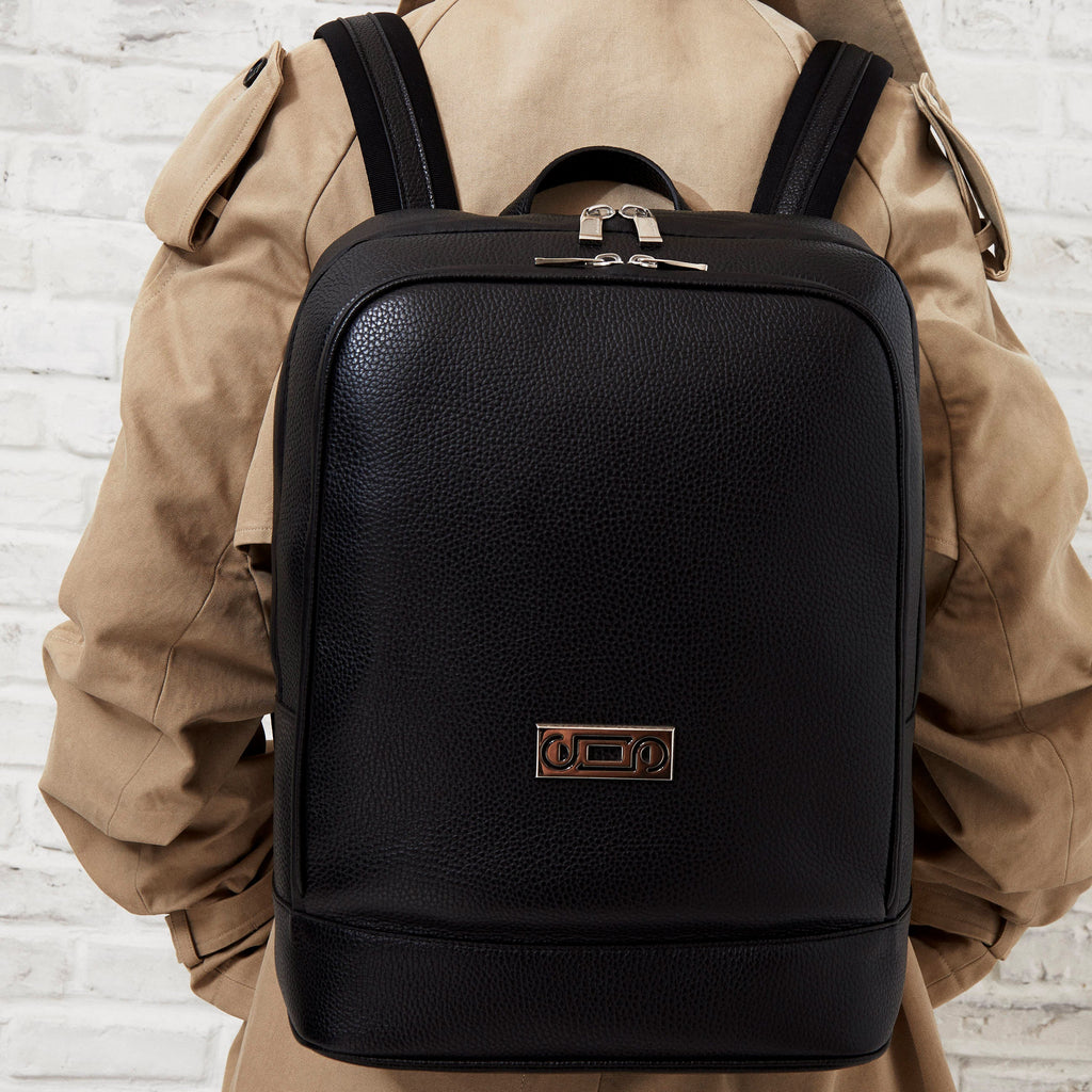 Model wearing The Simona Monochrome Backpack in black pebbled leather, expressing contemporary functionality and understated sophistication.