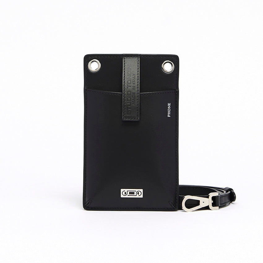 The Come Fly With Me! in Black. Front view showing smooth Italian leather, compact crossbody silhouette with external phone pocket and sturdy brass hardware plated in palladium.