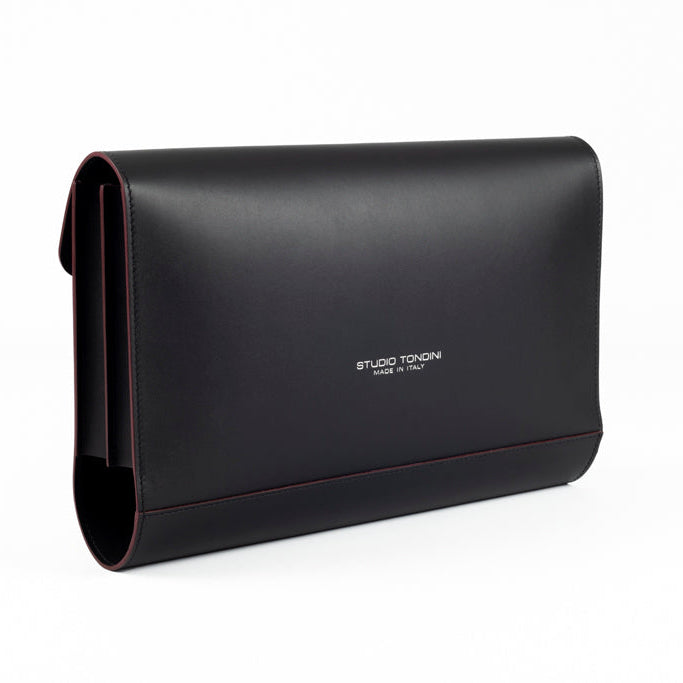 The Document Holder by Studio Tondini. Three-quarter view of black leather bag with burgundy edge paint, highlighting impeccable craftsmanship and dual-compartment structure.